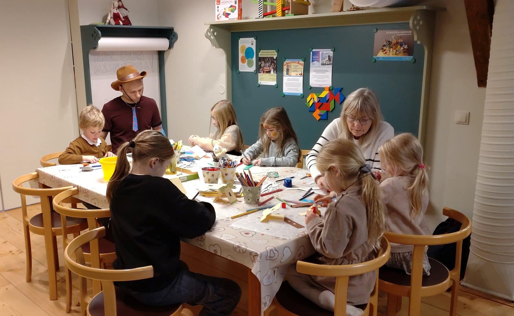 lapsed_koos_perega_ja_vanavanematega_meisterdavad_Tartu_kesklinna_manguasjamuuseumis