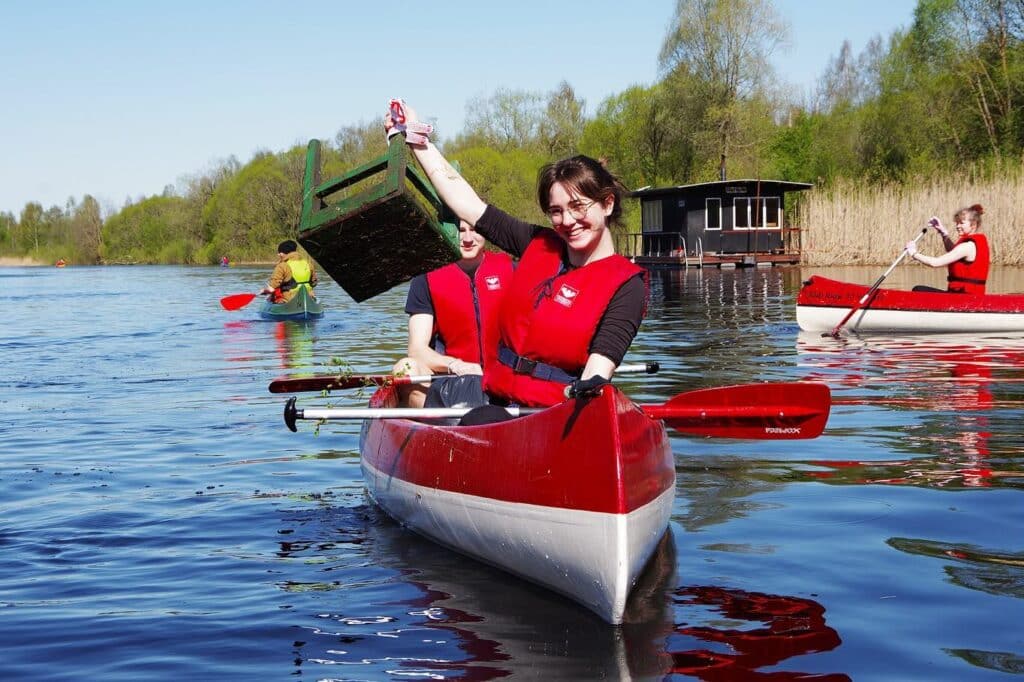 Punastes päästevestides talgulised koristavad kanuudega jõge ning tõstavad veest välja suuremat prügi Teeme Ära talgupäevade raames.