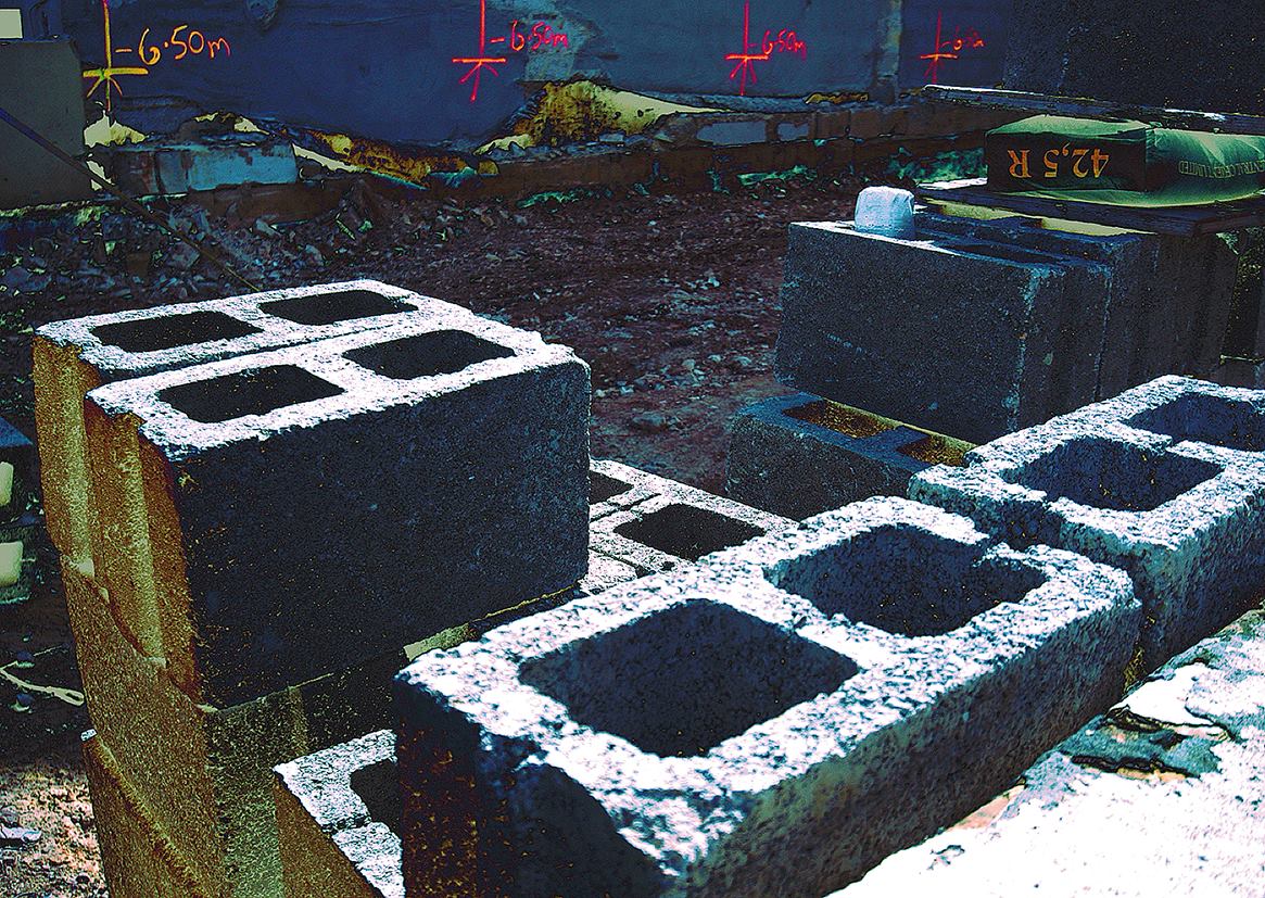 Betoonimuinasjutud, Betoonplokid Tartu ehitusplatsil, mille taustal on sinine sein punaste märgistuste ja mõõtudega.