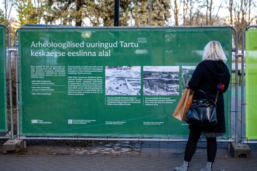 Inimene loeb Tartus Siuru arheoloogilisi uuringuid tutvustavat infotahvlit