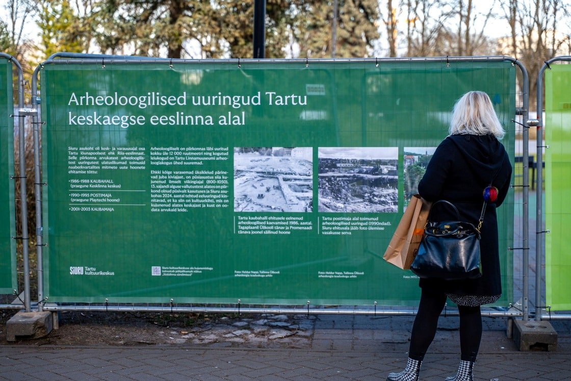 Inimene loeb Tartus Siuru arheoloogilisi uuringuid tutvustavat infotahvlit