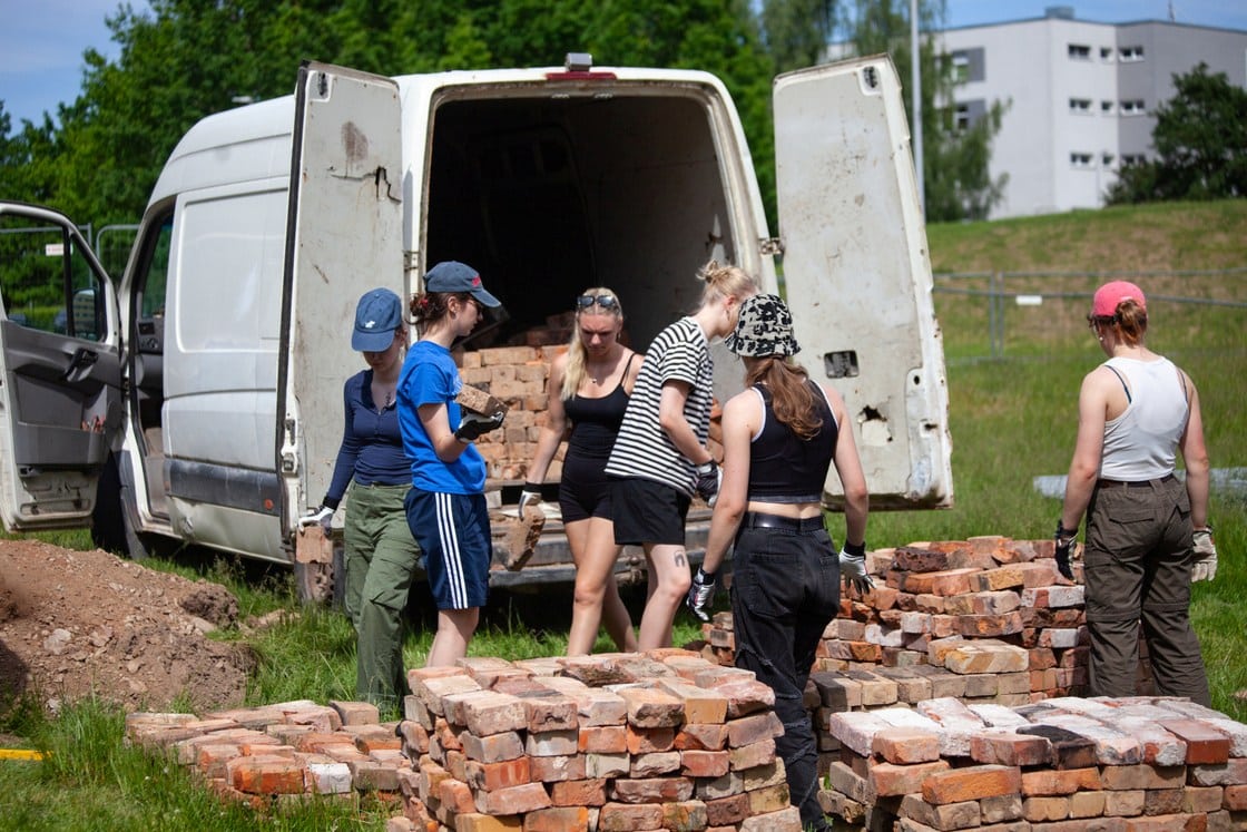 Mitu EKA tudengit ladumas telliskive valgest kaubikust.
