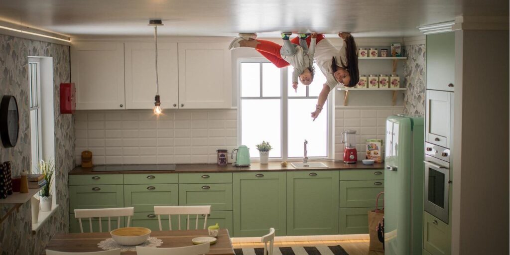 A woman with a child exploring the Upside Down House kitchen